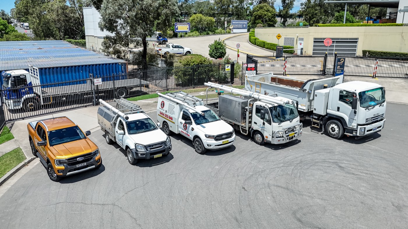 Aerial side view of a business fleet of utes and trucks
