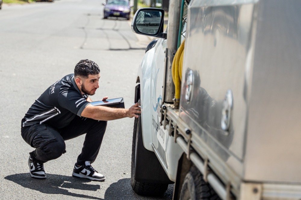Kerbside wheel and tyre check on a work ute