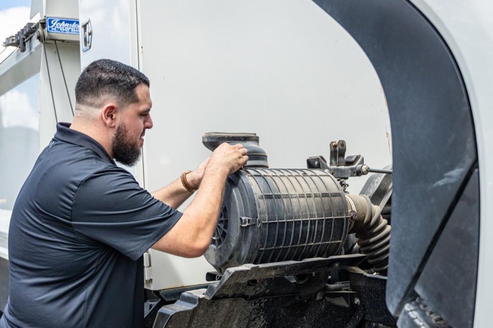 Technician checking a truck air filter during a scheduled service