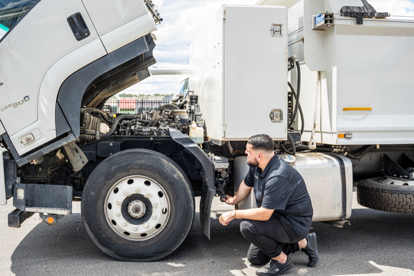 Inspector checking a truck wheel and chassis for registration compliance