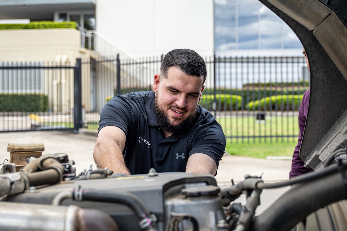 Technician servicing a truck engine with the cab tilted forward