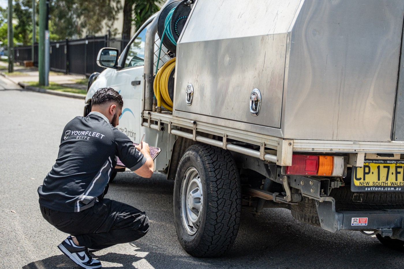 Technician inspecting a ute tyre and wheel for wear and pressure